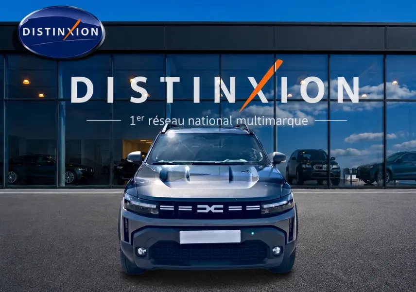 Vue avant du Dacia Duster 1.2 mild hybrid 140 Journey gris schiste avec calandre et phares LED distinctifs.