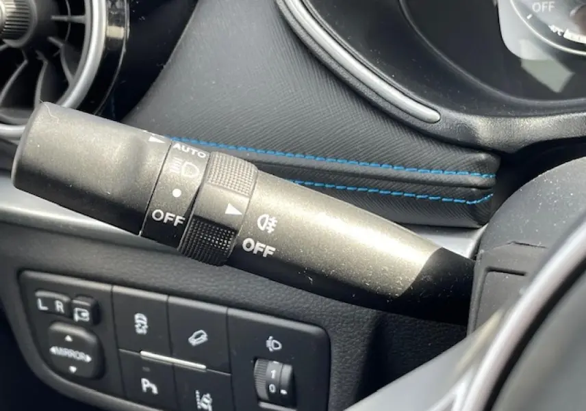 Gros plan sur la commande des phares et les boutons de réglage côté gauche du tableau de bord du SERES 3 noir métal.