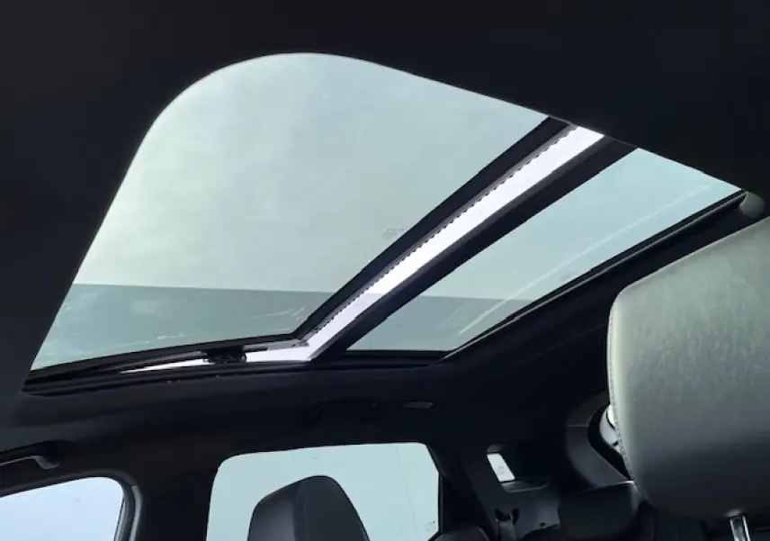 Toit panoramique ouvert vu de l'intérieur arrière d'un SERES 3 Luxury noir métal avec sièges en similicuir.