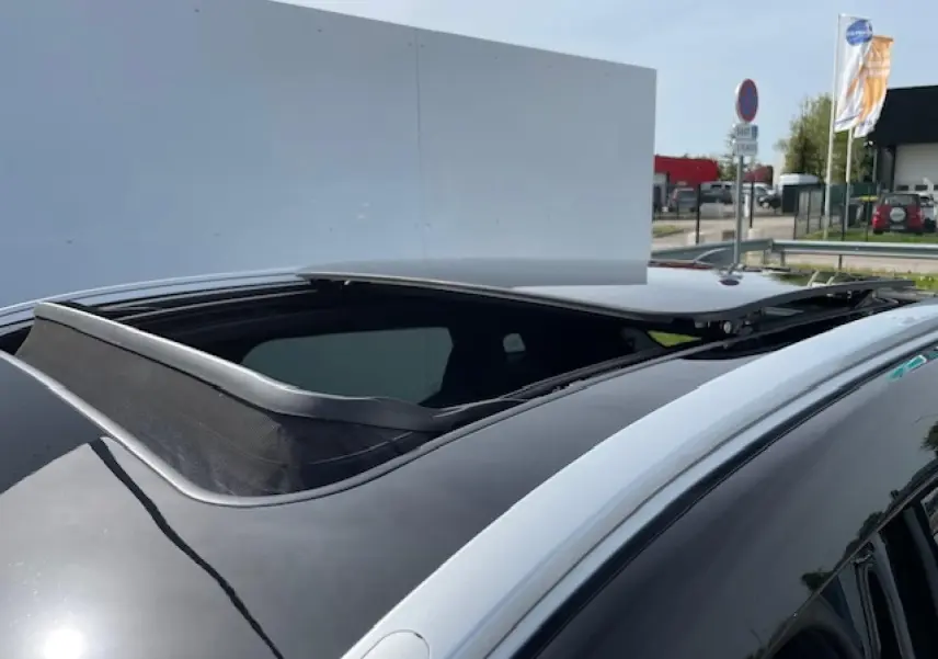 Toit panoramique ouvert en verre sur un SUV électrique SERES 3 Luxury noir métal, vue rapprochée côté droit.