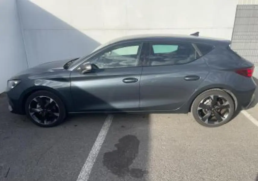 Profil côté gauche d'une CUPRA Leon 2025 gris magnetic metal avec jantes alliage noires et lignes dynamiques.