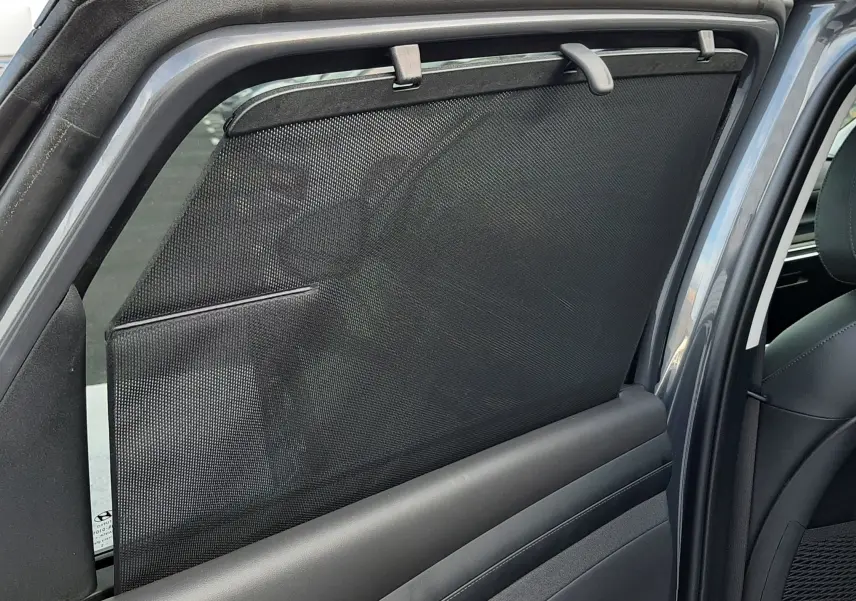 Store pare-soleil déployé sur la porte arrière côté gauche d’un Hyundai Tucson 2025 gris Ecotronic.