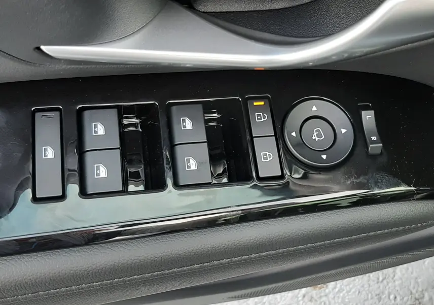 Gros plan sur les commandes de lève-vitres et rétroviseurs côté conducteur d'un Hyundai Tucson 2025 finition Executive.