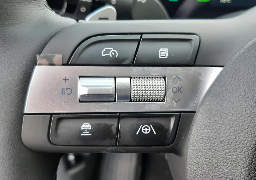 Gros plan sur les commandes de régulateur de vitesse et assistance au volant du Hyundai Tucson 2025, volant cuir noir.