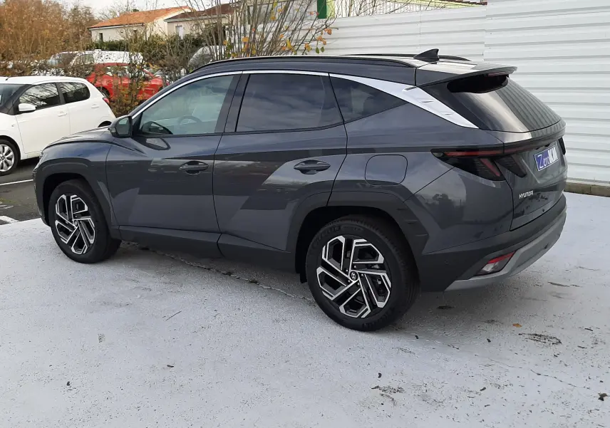 Hyundai Tucson 2025 gris Ecotronic vu en 3/4 arrière droit, avec jantes alliage 19 pouces et feux LED arrière fins.