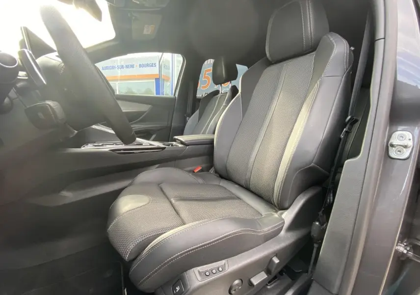 Vue intérieure côté conducteur du siège avant en cuir noir avec surpiqûres blanches du Peugeot 3008 gris foncé 2023.