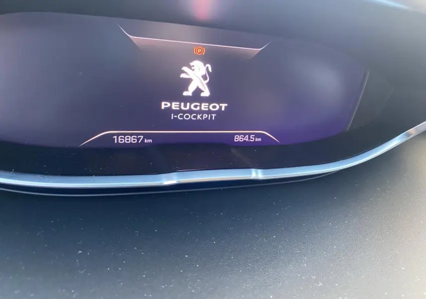 Affichage numérique du tableau de bord Peugeot i-Cockpit du 3008 hybride, montrant le logo et le kilométrage.