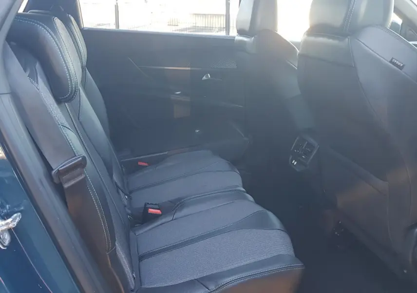 Vue intérieure côté gauche des sièges arrière en tissu et cuir sur Peugeot 5008 bleu 2024 avec ceinture de sécurité visible.