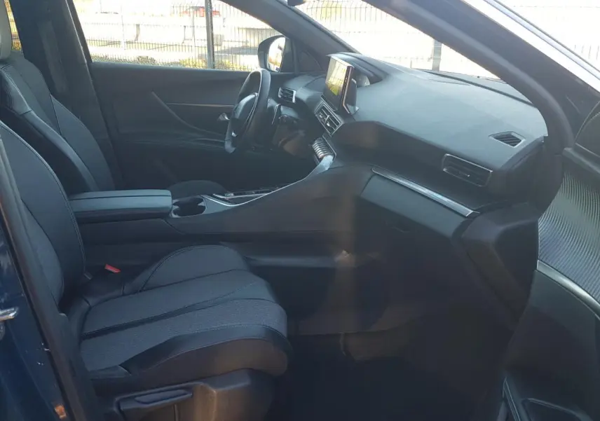 Vue intérieure côté conducteur du Peugeot 5008 bleu 2024, mettant en valeur les sièges réglables et l’écran tactile central.