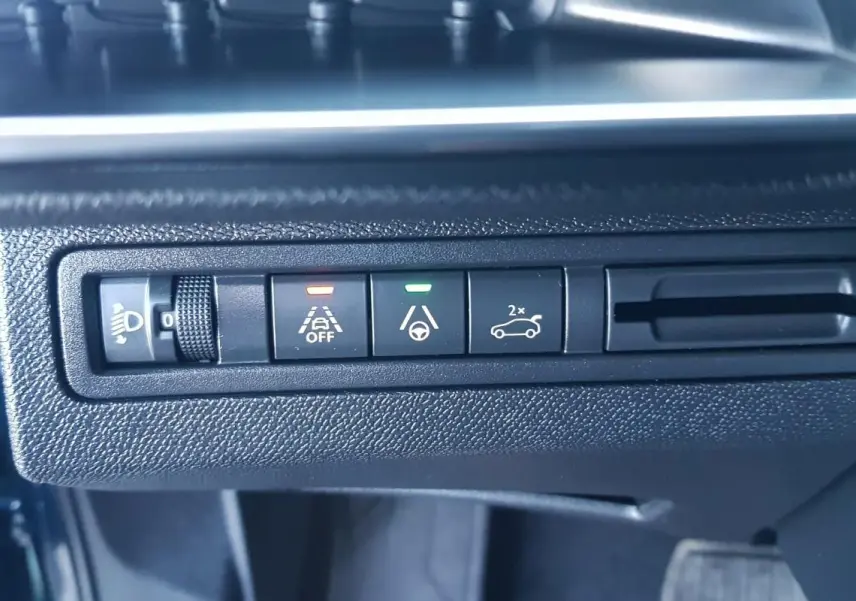 Gros plan sur les commandes d’assistance à la conduite du tableau de bord d’un Peugeot 5008 bleu 2024.