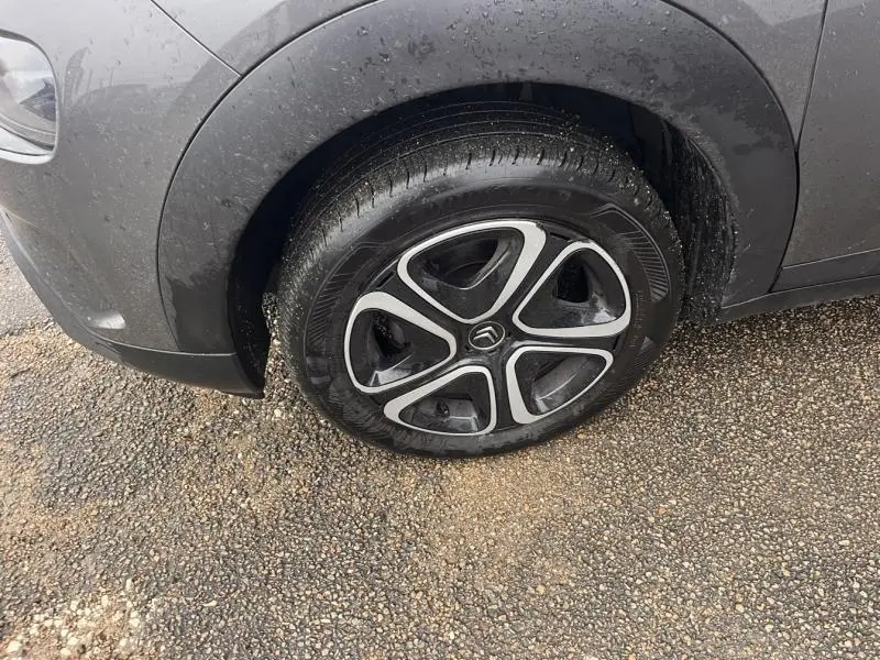 Gros plan sur la roue avant gauche d'une Citroën C4 Cactus gris Platinium avec jante alu 16 pouces Steel & Design.