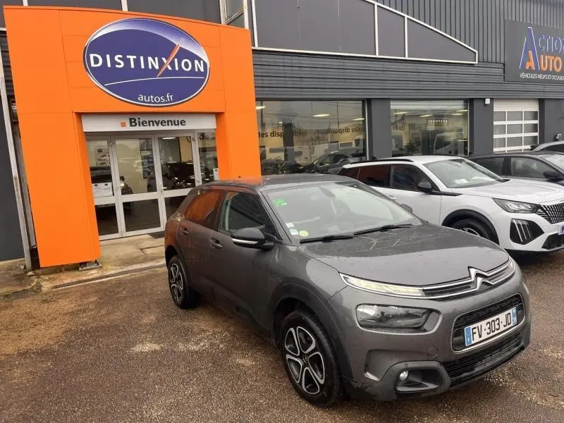 Vue 3/4 avant droite d'une Citroën C4 Cactus gris Platinium avec jantes noires et détails noirs brillants.