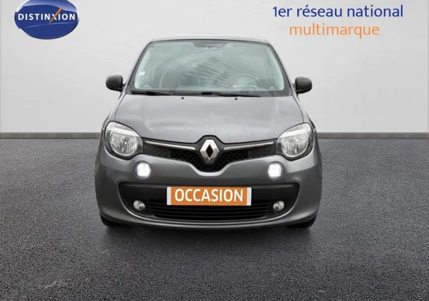 Vue frontale d'une Renault Twingo III gris foncé avec phares allumés et plaque "OCCASION" visible.