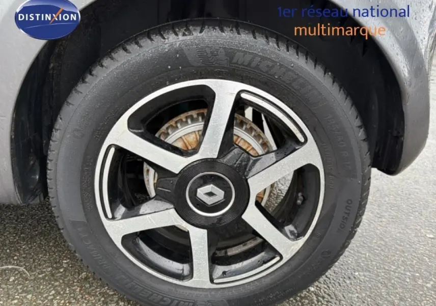 Gros plan sur la jante alliage 15 pouces noire et grise d'une Renault Twingo III gris foncé, avec logo central Renault.