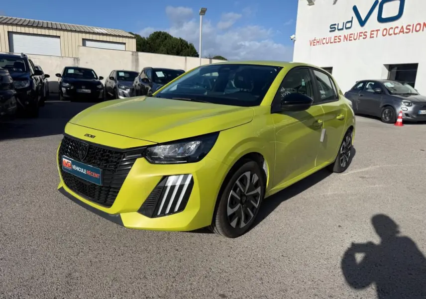 Peugeot 208 jaune vue 3/4 avant droit, avec calandre noire distinctive et jantes 16 pouces stylisées.