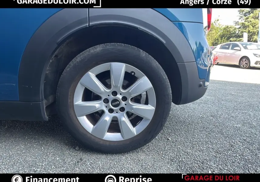 Gros plan sur la roue arrière droite argentée du MINI Countryman Cooper bleu, avec partie basse de la carrosserie visible.