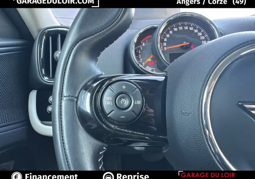 Gros plan sur le volant cuir noir de la MINI Countryman 2020 avec commandes de régulateur de vitesse et tableau de bord partiel.
