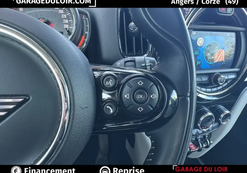 Gros plan sur le volant cuir noir côté droit du MINI Countryman 2020 avec commandes multifonctions et écran tactile visible.