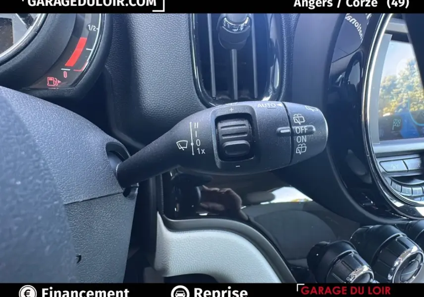 Gros plan sur la commande d'essuie-glace à gauche du volant dans l'habitacle noir et gris d'une MINI Countryman 2020.