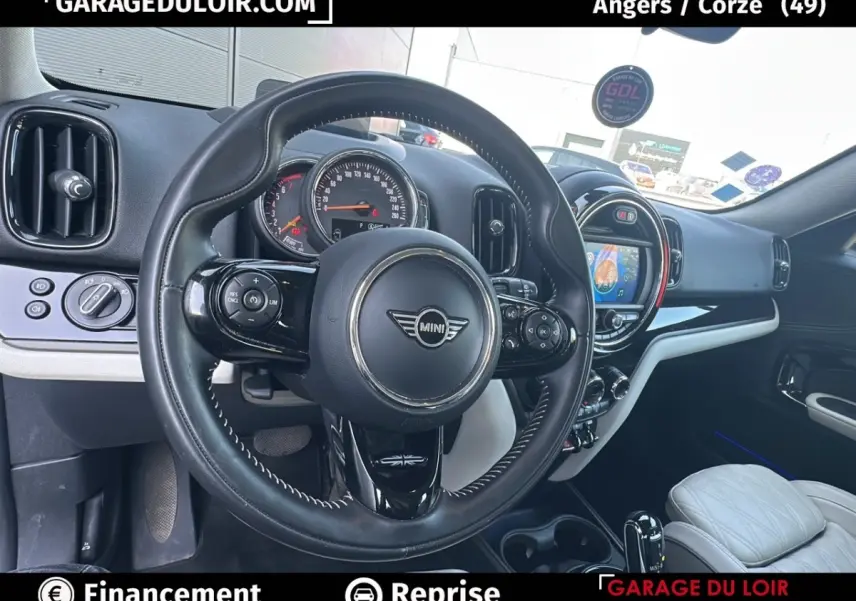 Vue intérieure centrée sur le volant cuir noir et le tableau de bord avec écran tactile du MINI Countryman 2020.
