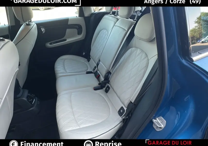 Vue côté droit sur l'intérieur arrière d'une MINI Countryman bleu avec sièges cuir beige matelassés.