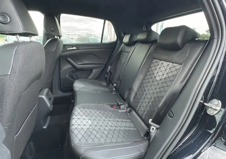 Vue intérieure côté droit montrant la banquette arrière tissu noir et gris du Volkswagen T-Cross TSI 116 DSG7 R-Line 2025.