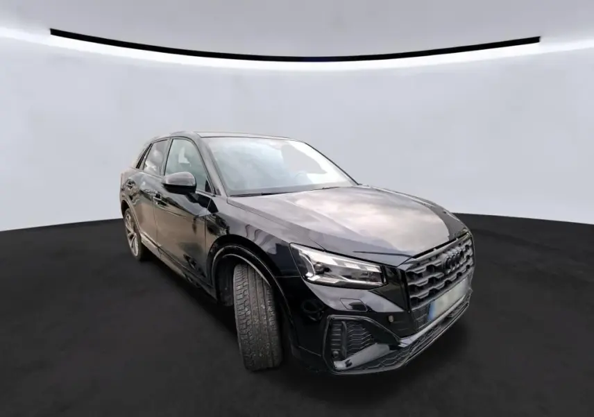 Audi Q2 noir vue de face dans un garage avec calandre noire et plaque Distinxion visible.