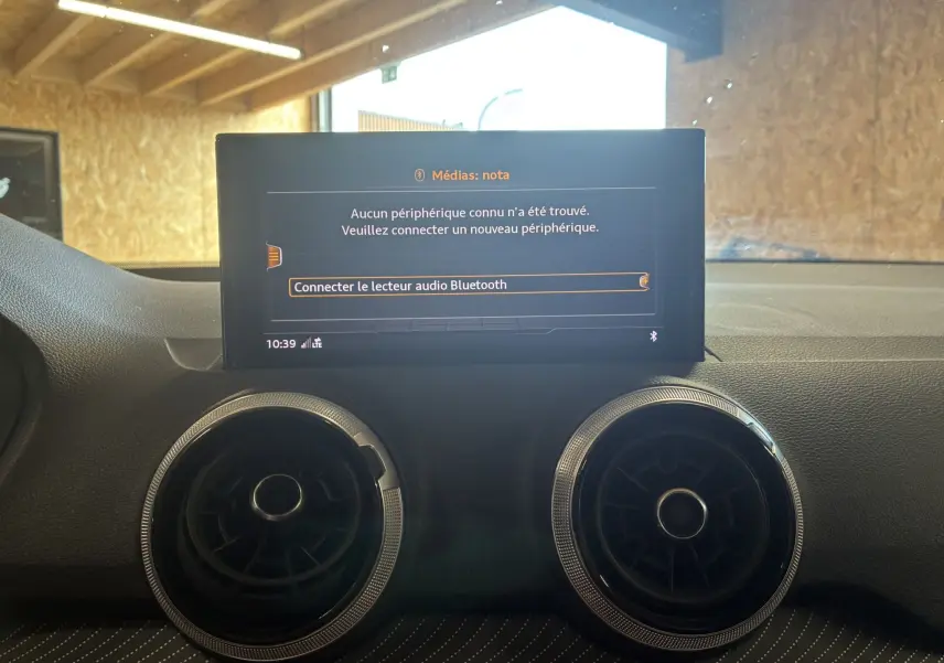 Écran central de l'Audi Q2 2023 affichant un message de connexion Bluetooth, avec deux aérateurs ronds en dessous.