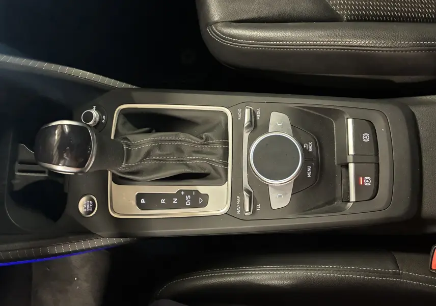 Vue rapprochée de la console centrale noire de l’Audi Q2 2023 avec levier de vitesse automatique et commandes multimédia.