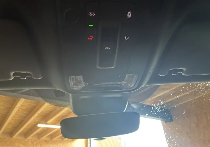 Vue intérieure du plafonnier noir de l'Audi Q2 2023 avec commandes lumineuses et rétroviseur central.