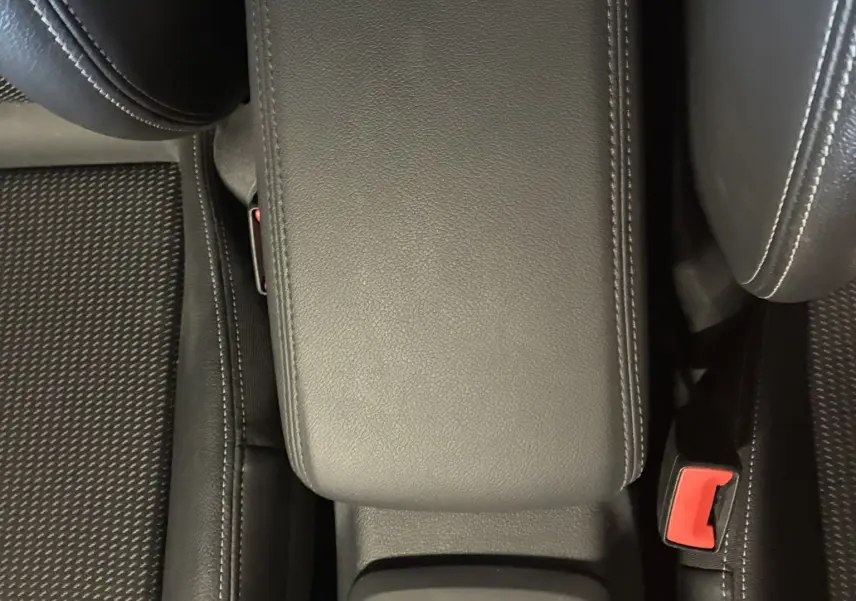 Vue plongeante sur l'accoudoir central noir et la console avec commandes du Audi Q2 2023 finition S-Line+