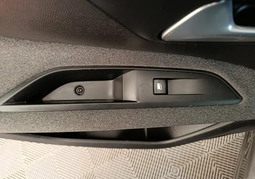 Détail de la commande d'ouverture de porte côté intérieur d'un Peugeot 3008 gris foncé, finition tissu.