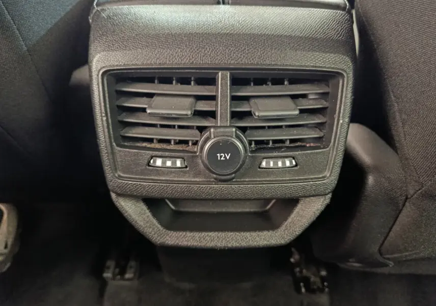 Vue rapprochée des bouches de ventilation arrière noires avec prise 12V du Peugeot 3008 gris foncé, version 2022.