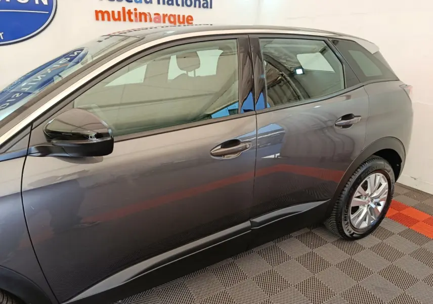 Vue latérale côté gauche du Peugeot 3008 gris foncé, mettant en valeur les lignes épurées et les rétroviseurs électriques.
