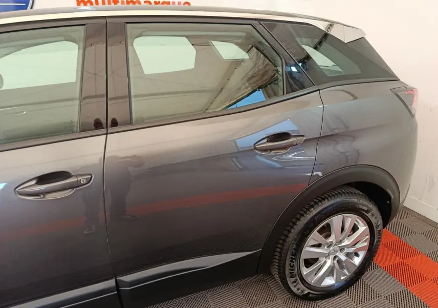 Vue côté droit arrière du Peugeot 3008 gris foncé 2022, mettant en valeur la roue et la ligne de caisse.