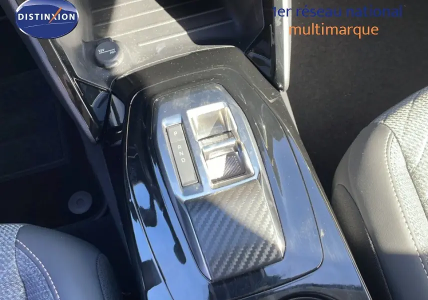 Vue rapprochée de la console centrale noire brillante avec sélecteur de boîte automatique sur Peugeot 208 jaune Agueda Metal.