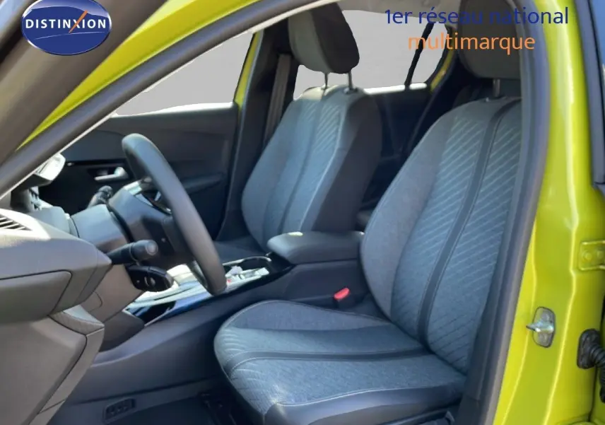 Vue intérieure côté conducteur de la Peugeot 208 Hybrid jaune Agueda, sièges tissu gris avec détails noirs.