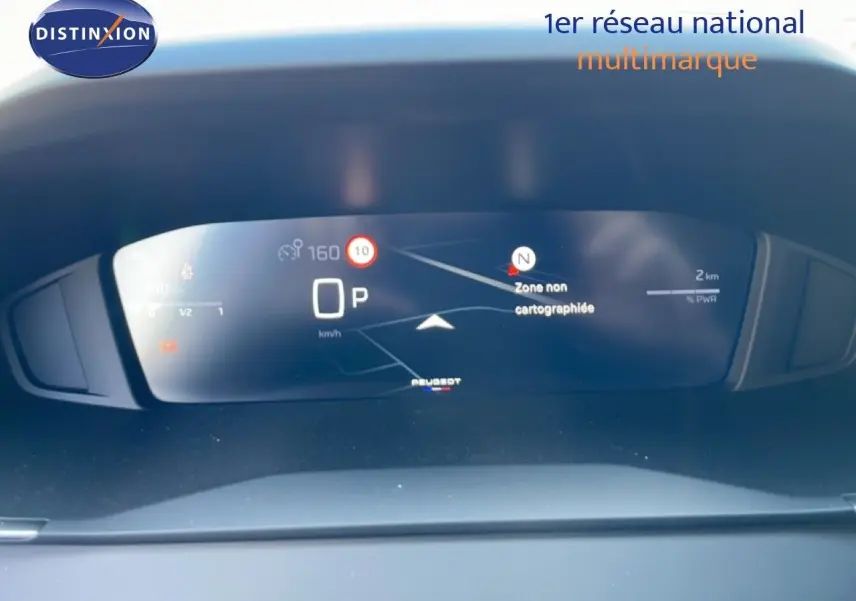 Tableau de bord numérique de Peugeot 208 Hybrid 110ch en vue frontale, affichant la navigation et la vitesse à l'arrêt.