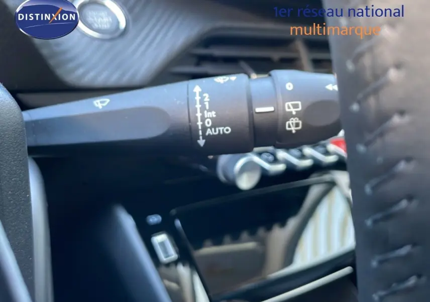 Gros plan sur la commande d’essuie-glace à gauche du volant dans l’habitacle d’une Peugeot 208 jaune Agueda Metal.