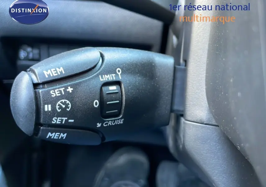 Gros plan sur la commande de régulateur de vitesse dans l’habitacle d’une Peugeot 208 jaune Agueda Metal 2026.