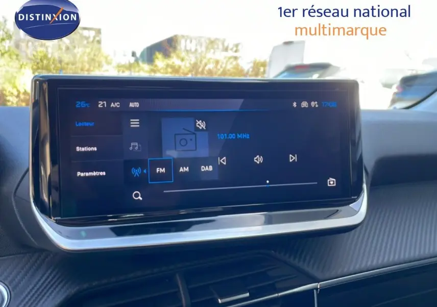 Écran tactile central de la Peugeot 208 Hybrid jaune Agueda, affichant les réglages radio FM en extérieur.