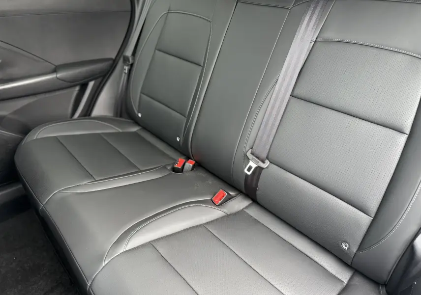 Vue intérieure du siège arrière en cuir noir du MG MOTOR ZS 1.5 HYBRID+ 197 LUXURY, avec ceinture de sécurité visible.