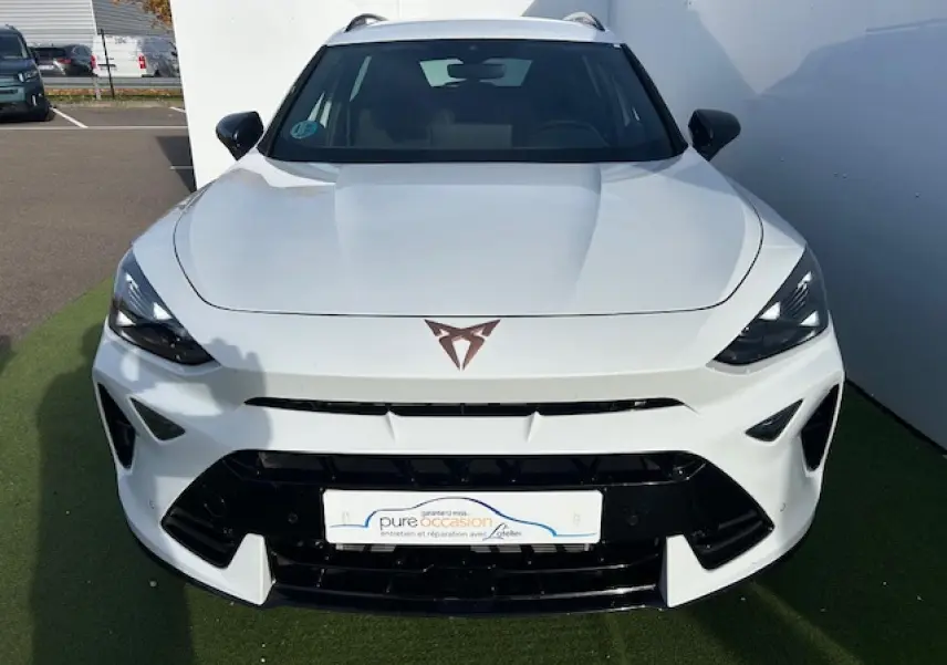 Vue de face d'un CUPRA Formentor blanc neige avec logo CUPRA cuivré et calandre noire brillante.