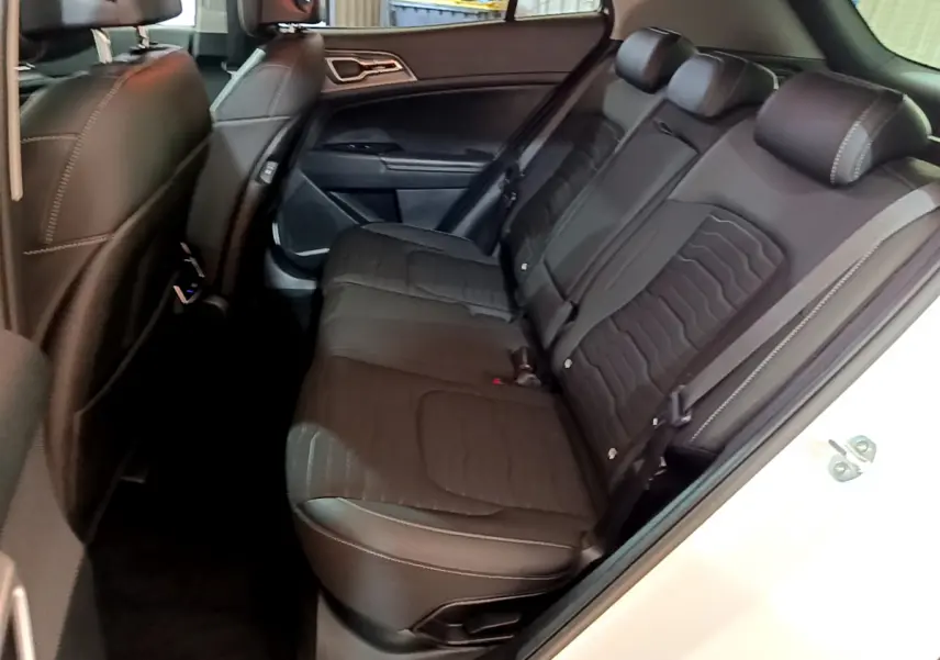Vue côté droit sur la banquette arrière noire du Kia Sportage blanc 2022 avec surpiqûres contrastées.