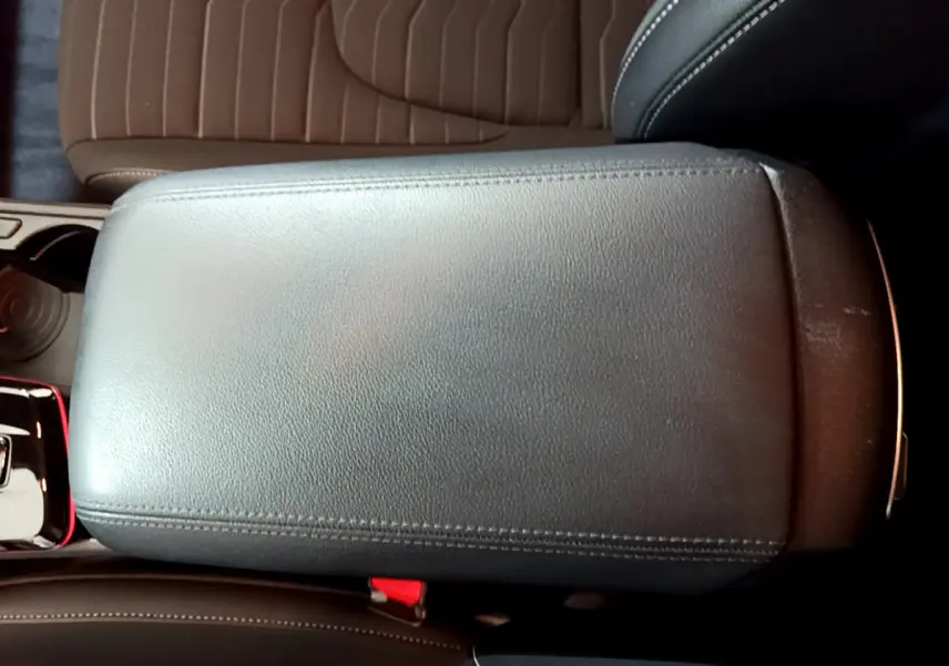 Accoudoir central noir en cuir vu de dessus dans l'habitacle du Kia Sportage blanc hybride 2022