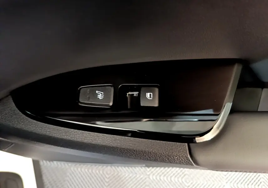 Gros plan sur les commandes de réglage des rétroviseurs côté conducteur du Kia Sportage blanc 2022.