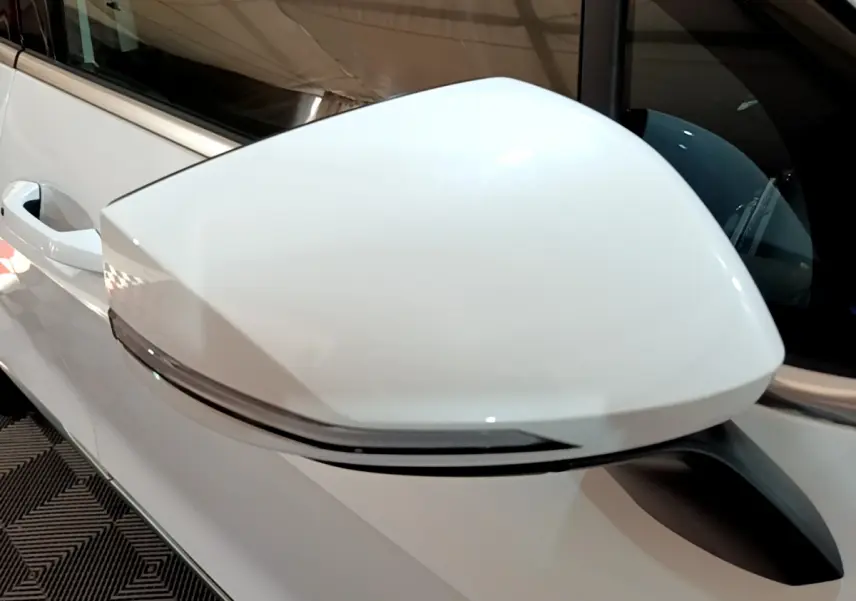 Gros plan sur le rétroviseur droit blanc du KIA SPORTAGE 2022 hybride rechargeable, avec clignotant intégré.