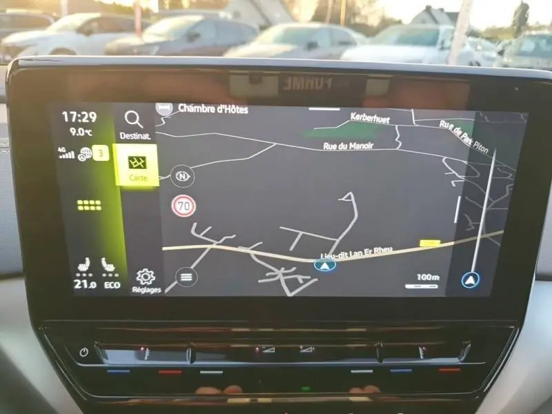 Écran tactile central du Volkswagen ID.4 2023 affichant la navigation GPS avec carte et réglages climatisation.