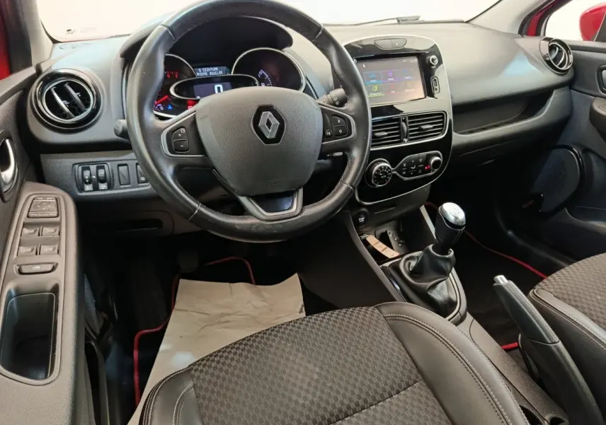 Vue intérieure avant de la Renault Clio Intens 2018, montrant le volant cuir, écran tactile 7 pouces et levier de vitesses manuel.