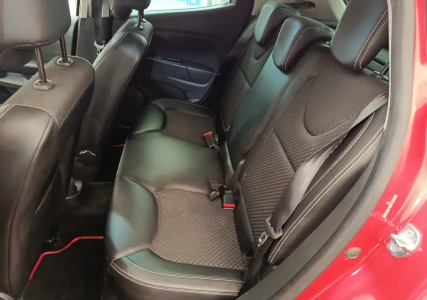 Vue intérieure côté droit des sièges arrière noirs en cuir et tissu d'une Renault Clio Intens rouge de 2018.